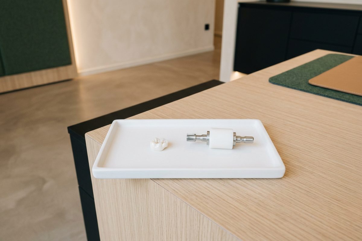 Illustrative object photograph of a milled ceramic restoration on a pale oak counter