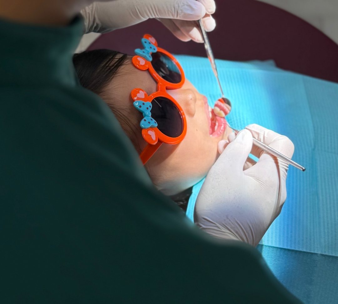 一名儿童在 Calm Dental 接受检查，配戴防护眼镜